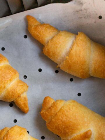 Crescent rolls in air fryer basket.