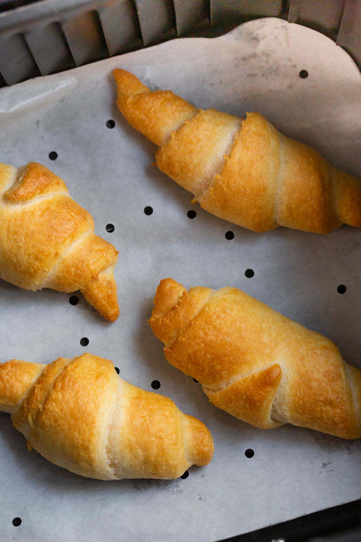 Crescent rolls in air fryer basket.