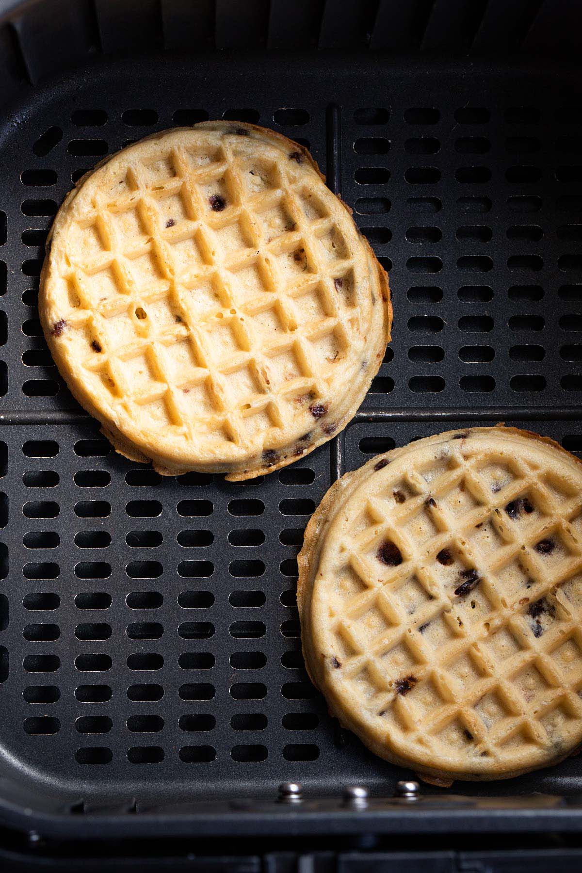 Cooked waffles in air fryer basket.