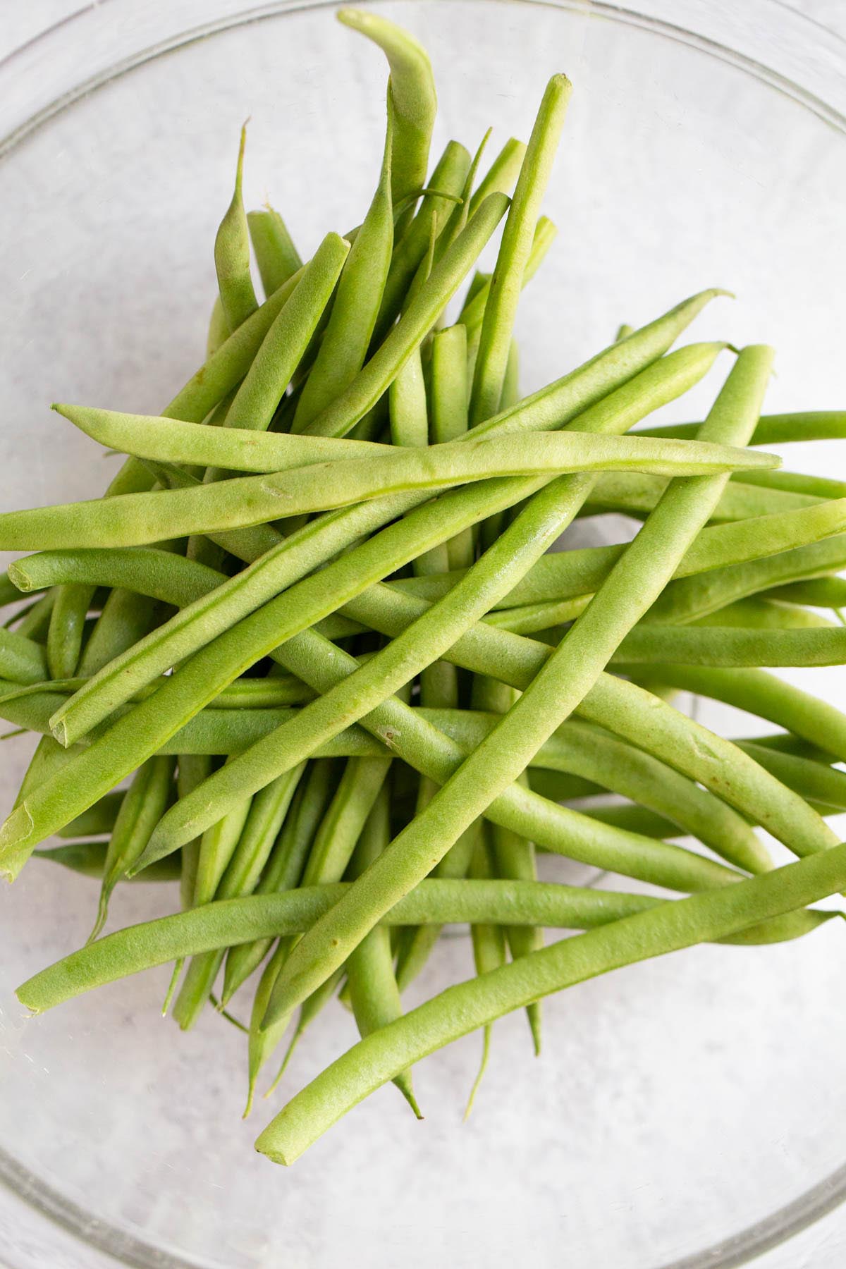 Raw green beans in a bowl.