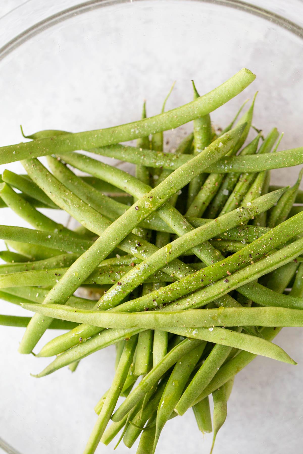 Green beans with seasonings in a bowl.