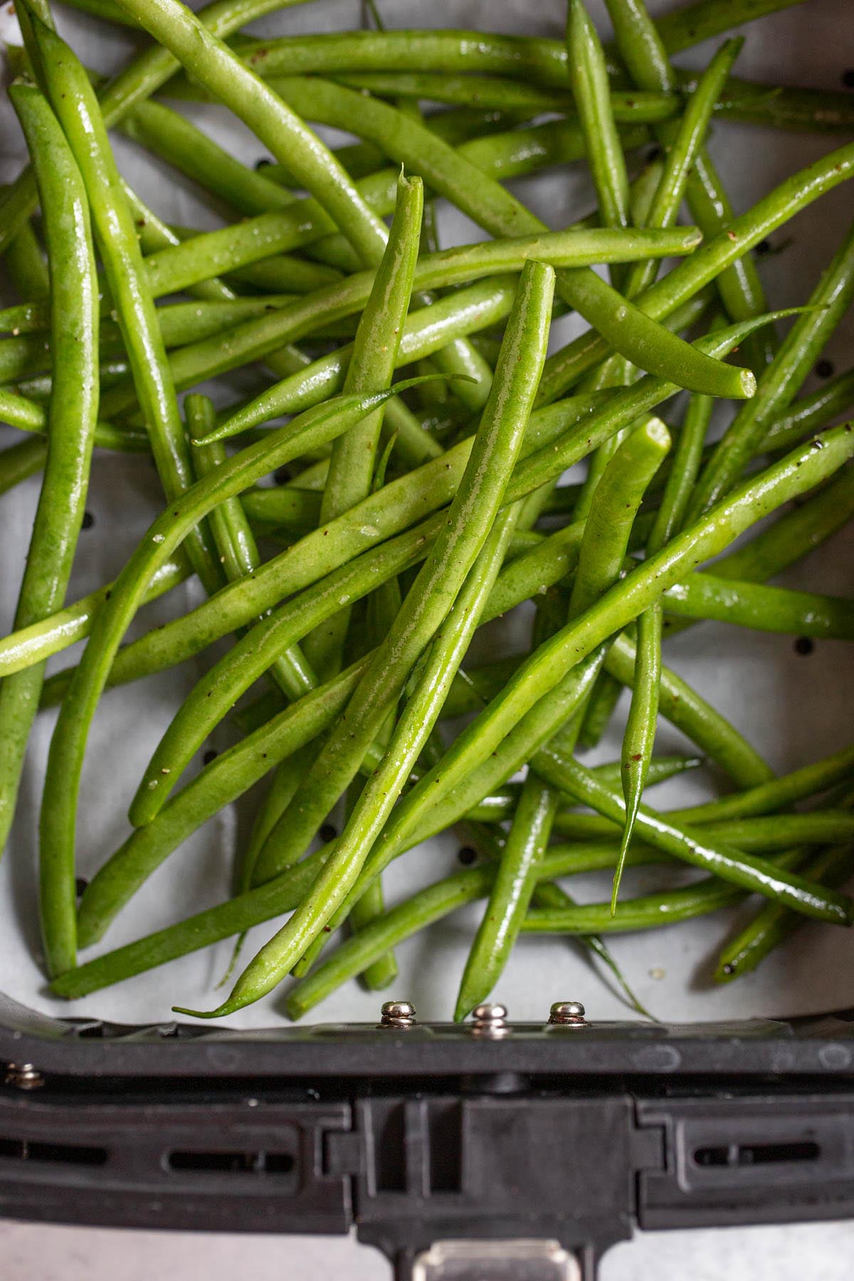 Uncooked green beans in air fryer.