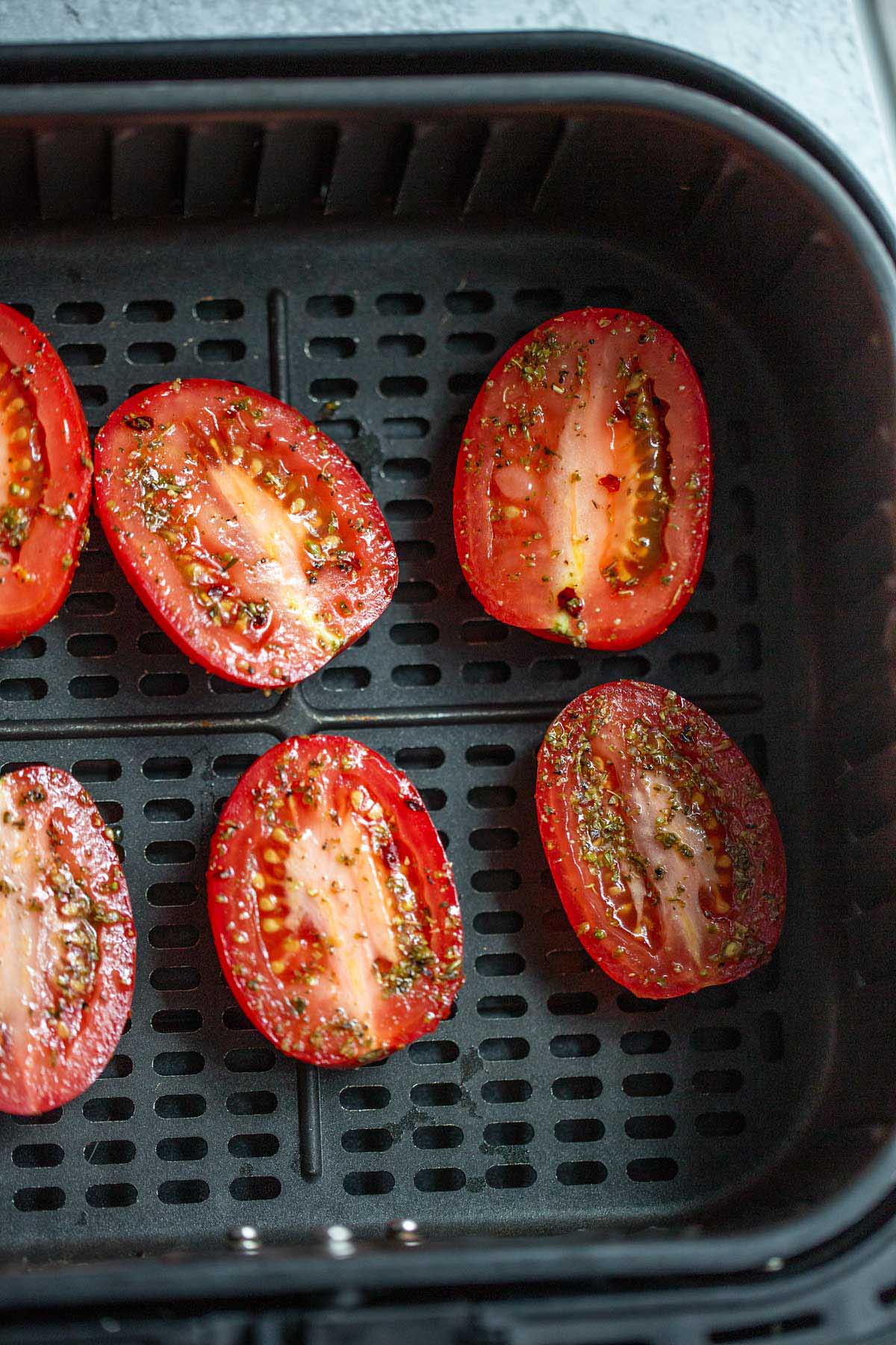 Roma tomatoes in air fryer basket