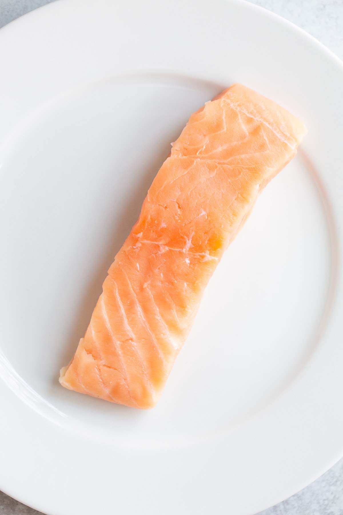 Raw salmon on a white plate.