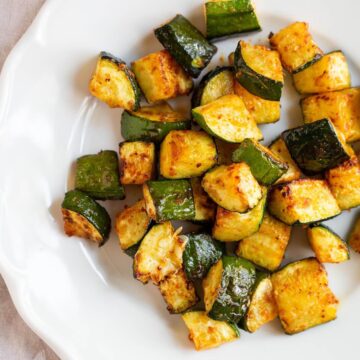 Air fryer zucchini on a white plate.