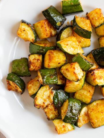 Air fryer zucchini on a white plate.