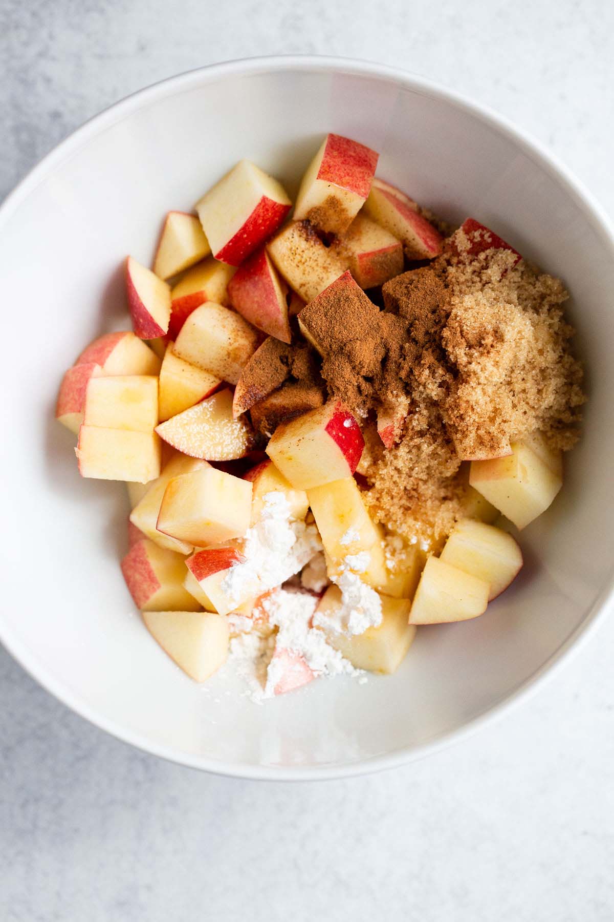 Diced apples plus seasonings in a bowl