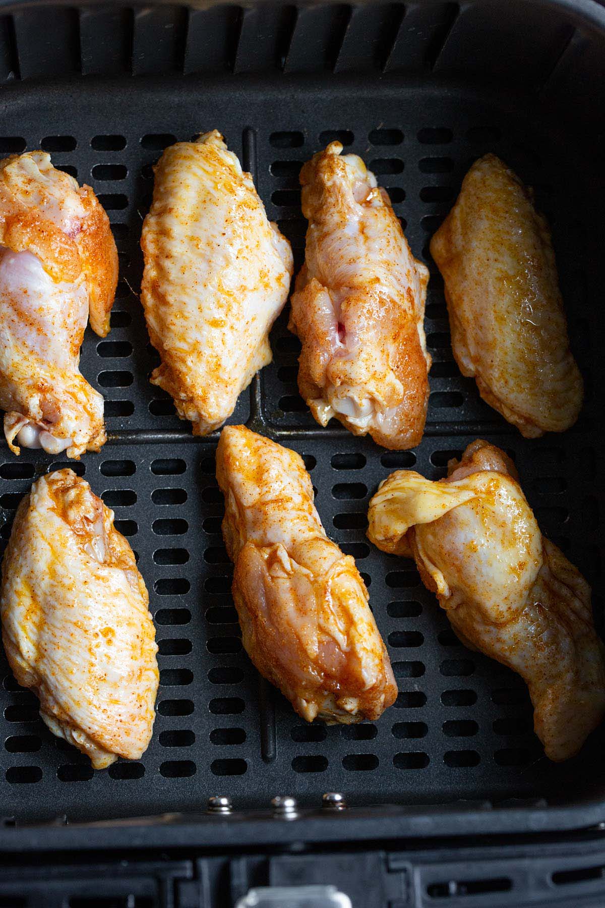 Uncooked chicken wings in air fryer.