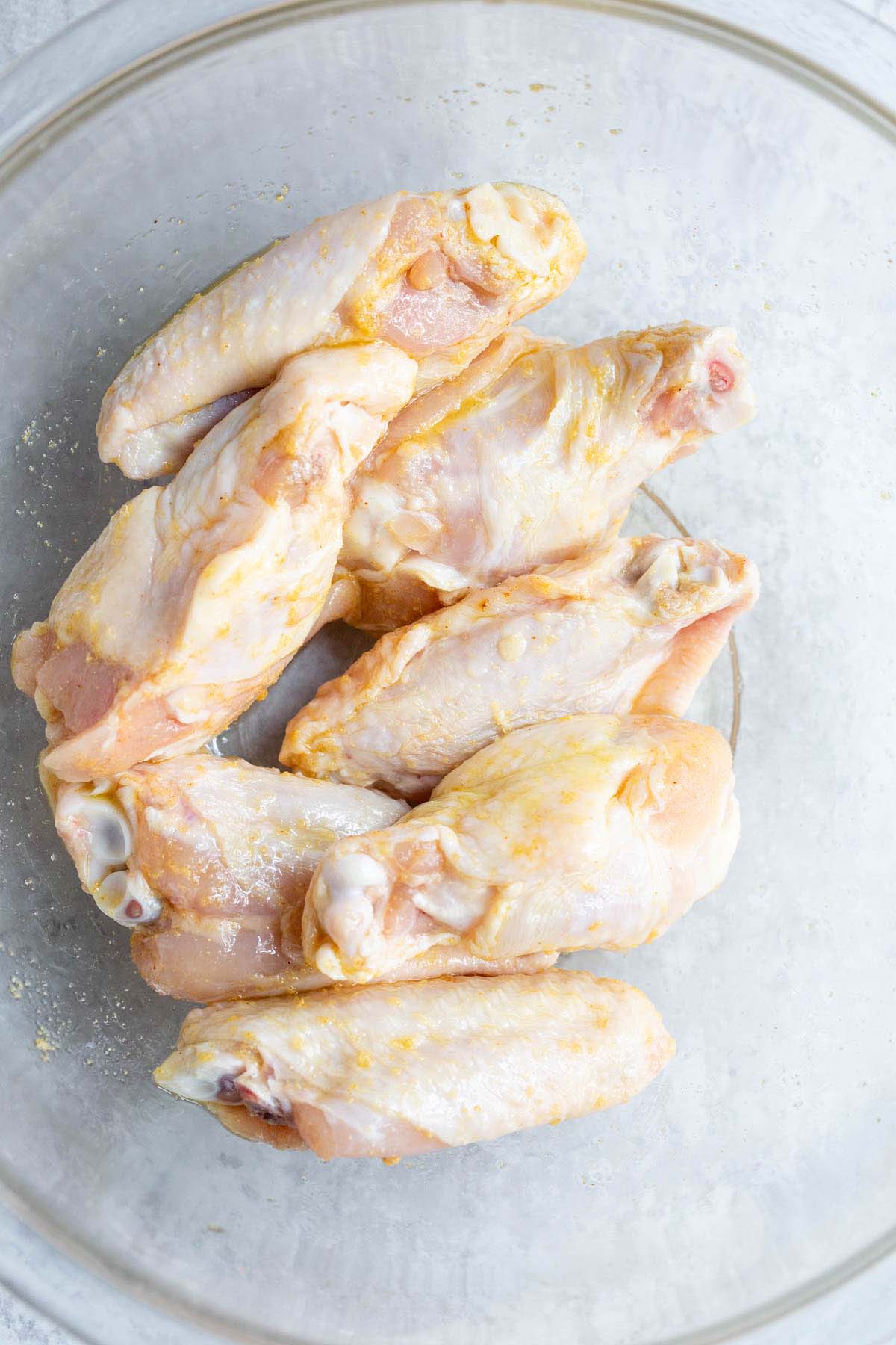 Raw chicken wings in a bowl.