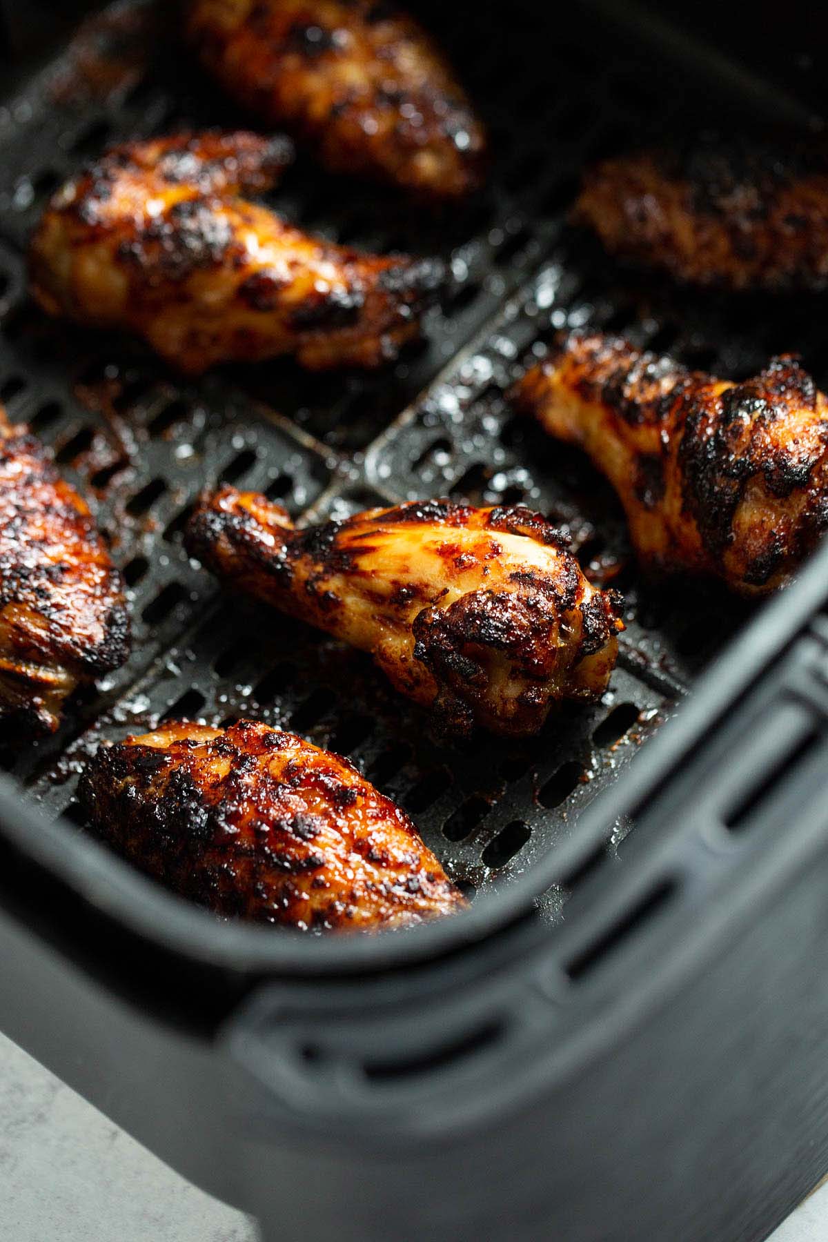 Air fryer honey garlic wings in air fryer basket.