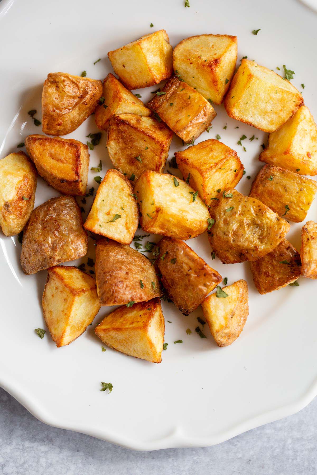 Air fried roasted potatoes on a white plate.