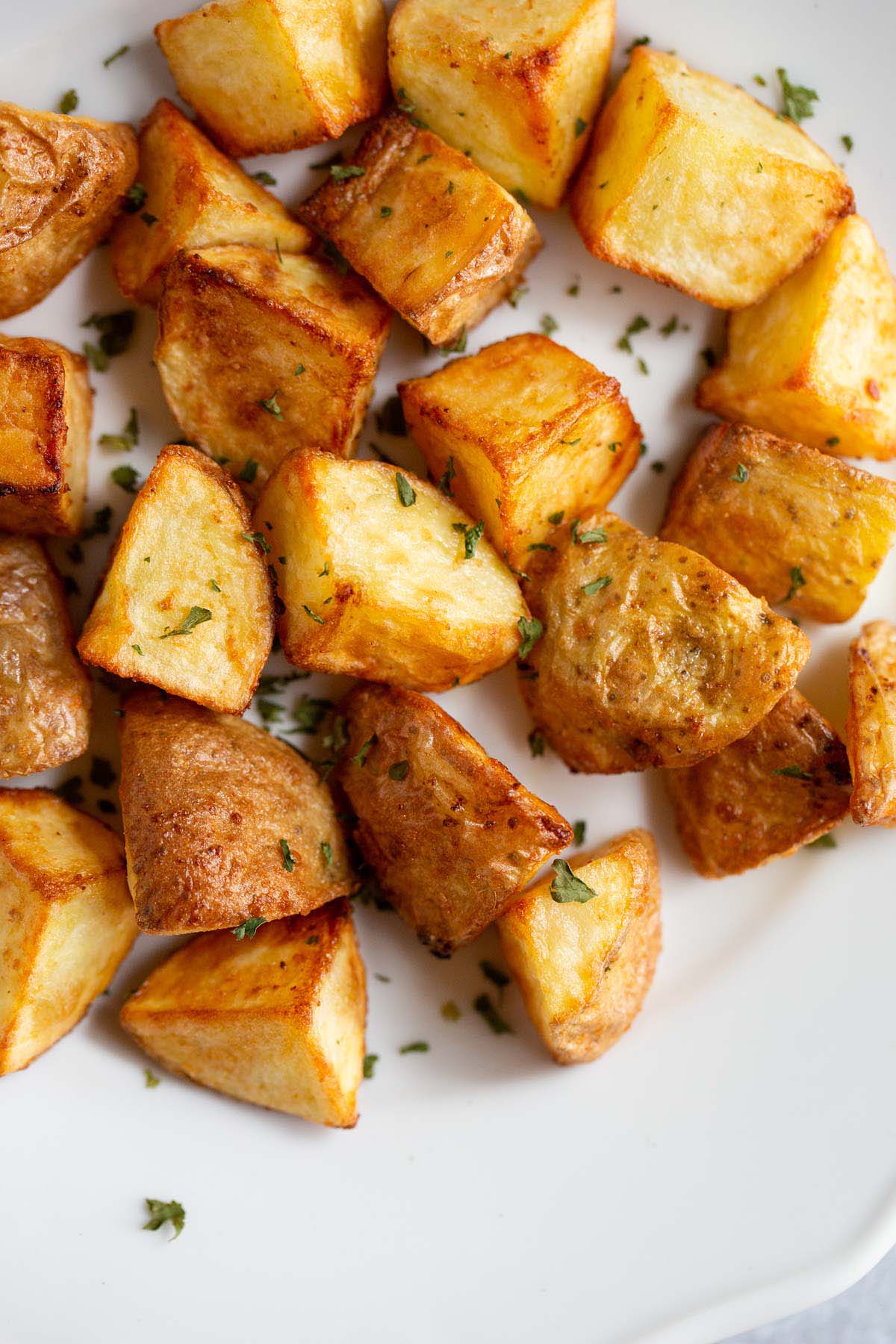 Air fried roasted potatoes on a white plate.