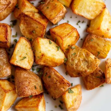 Air fried roasted potatoes on a white plate.