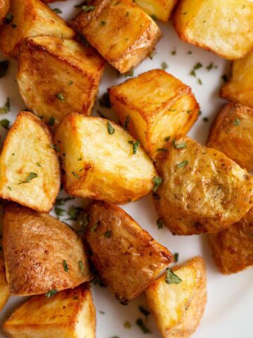 Air fried roasted potatoes on a white plate.