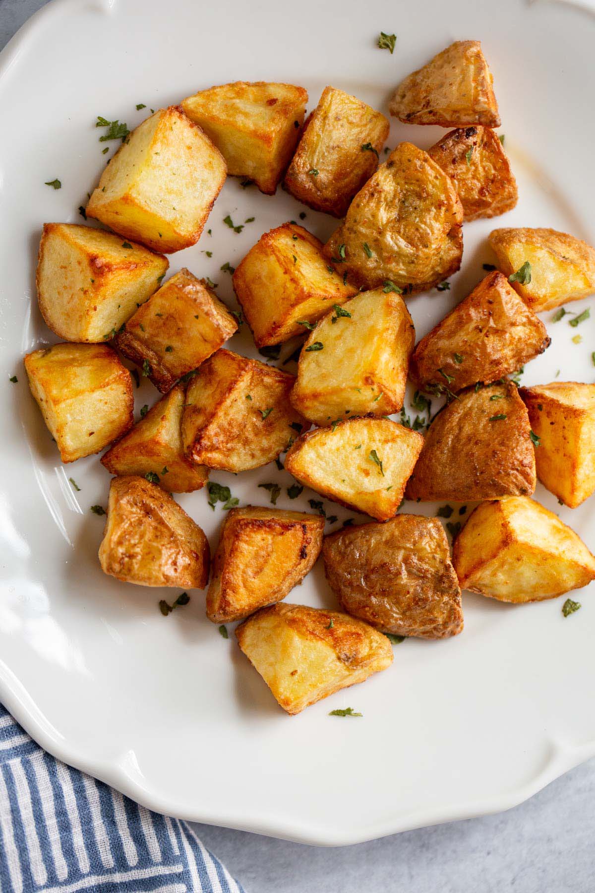 Air fried roasted potatoes on a white plate.