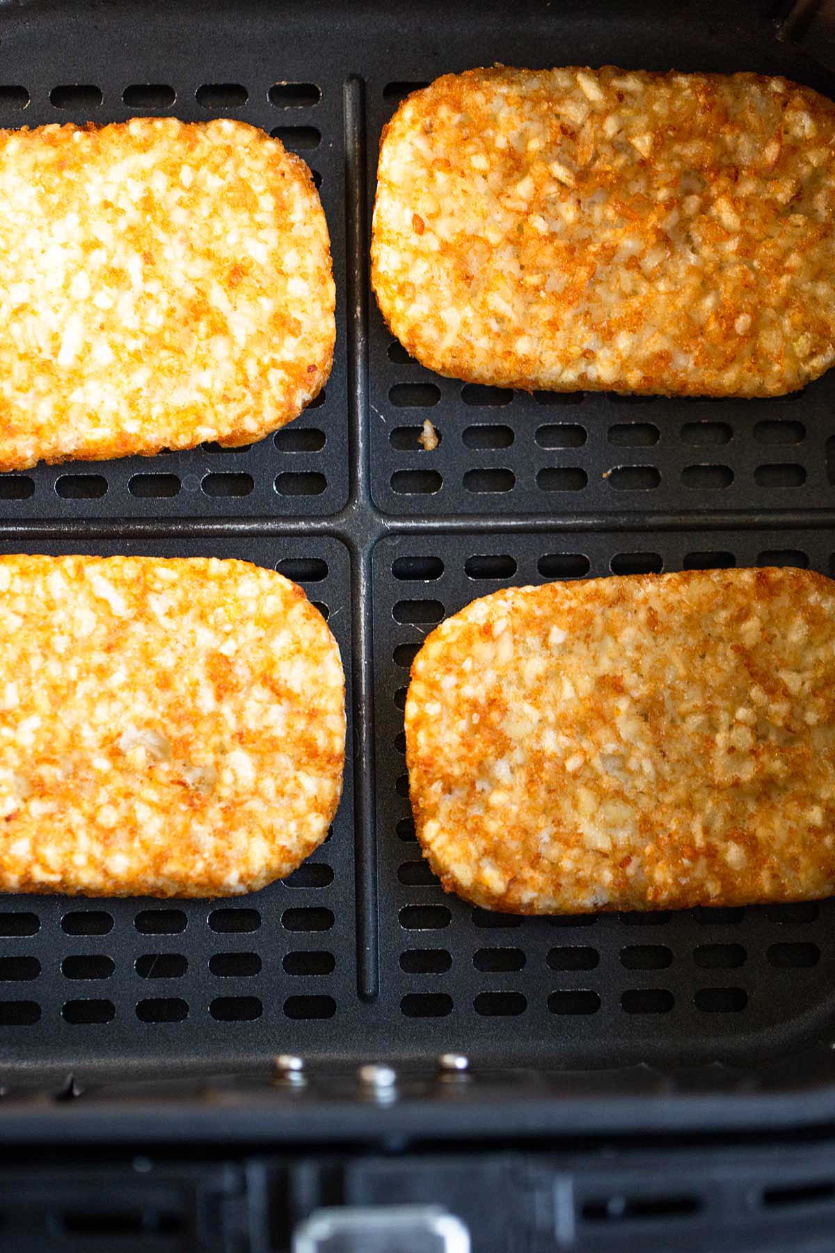 Trader Joe's hash browns in air fryer basket.