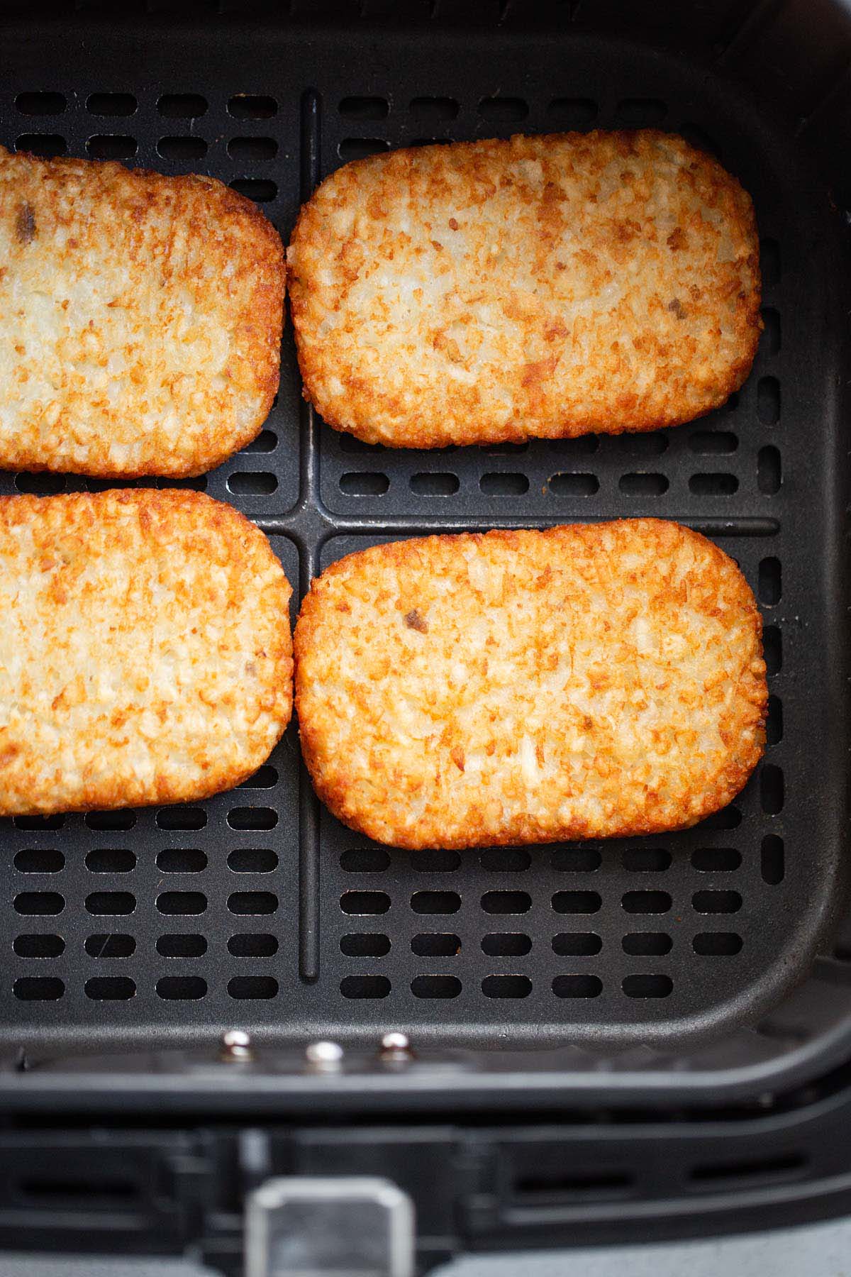 Cooked Trader Joe's hash browns in air fryer basket.