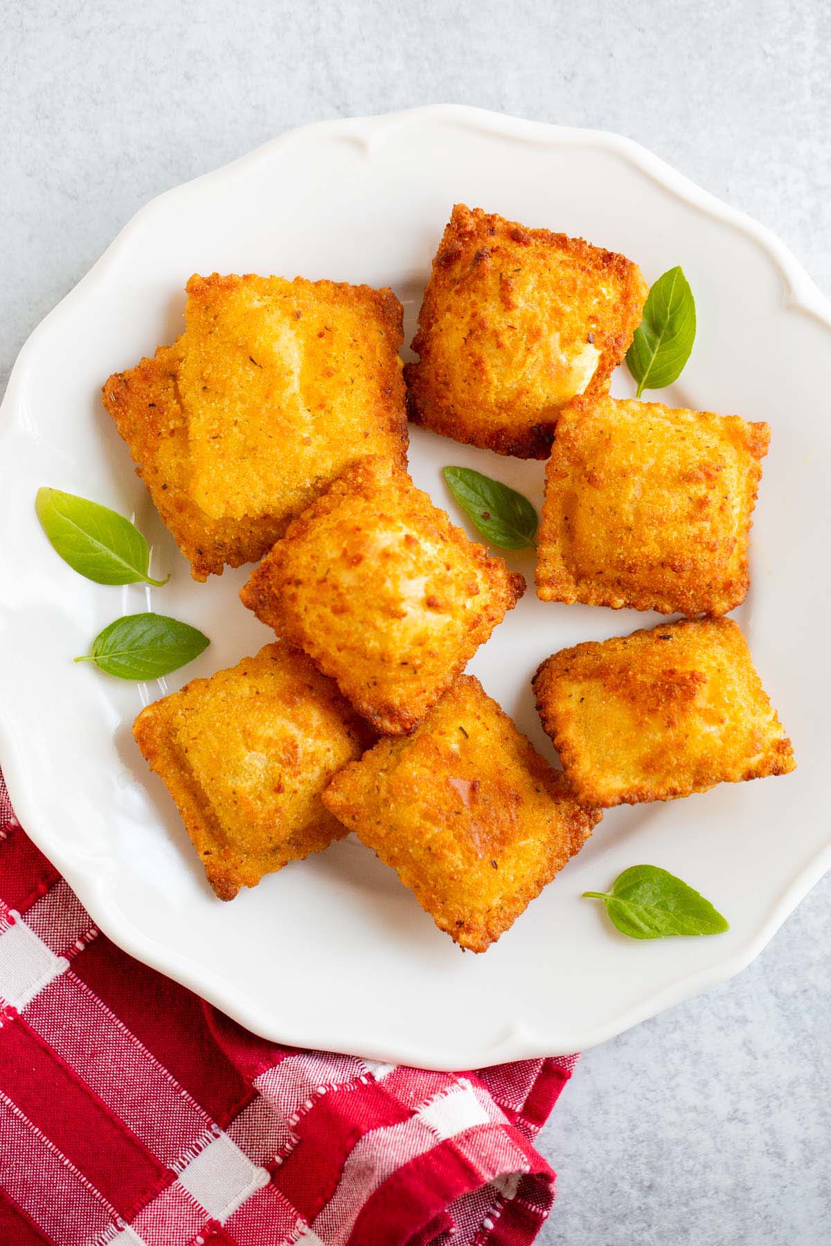 Air fried Trader Joe's breaded ravioli on a plate with basil leaves