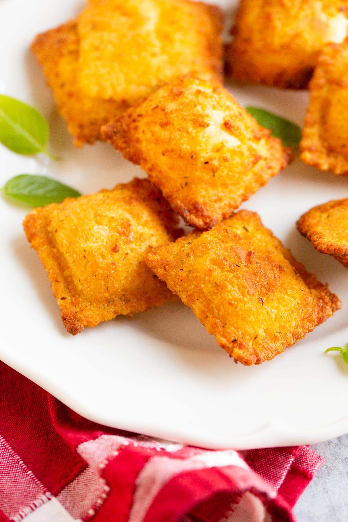 Air fried Trader Joe's breaded ravioli on a plate with basil leaves