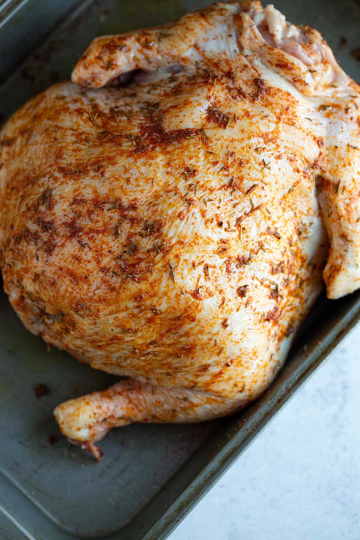 Uncooked whole chicken with spices.