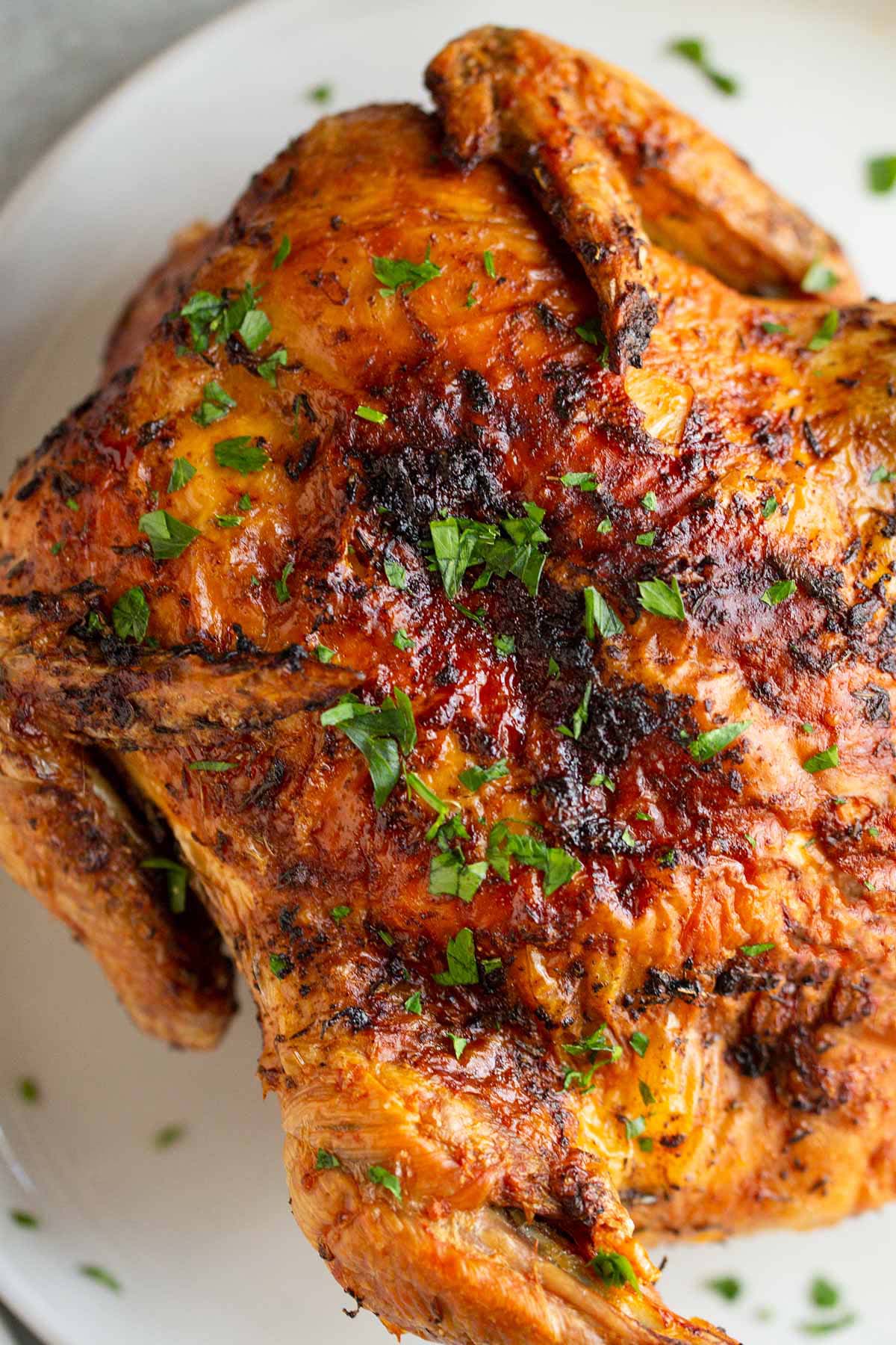 Air fried whole chicken with a parsley garnish.