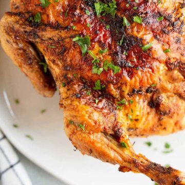 Air fried whole chicken with a parsley garnish.