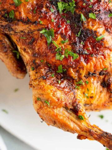 Air fried whole chicken with a parsley garnish.