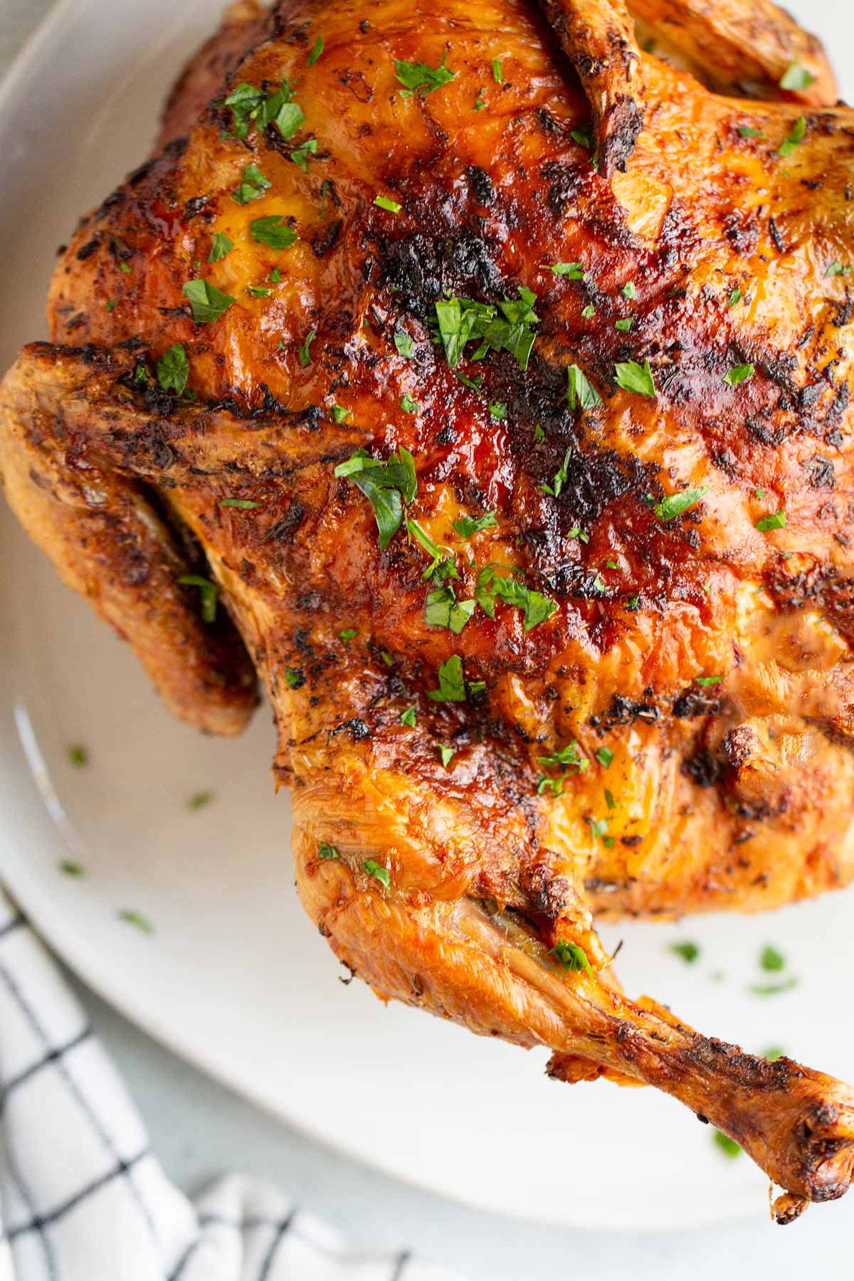 Air fried whole chicken with a parsley garnish.