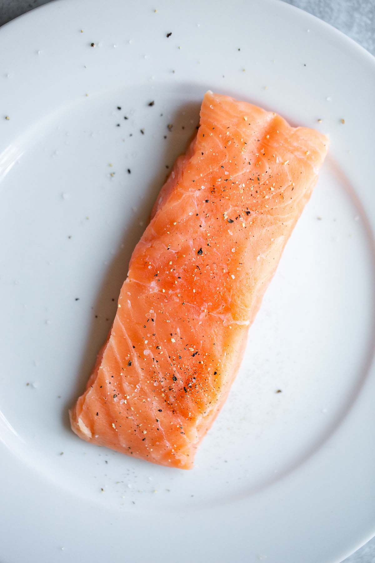 Uncooked salmon seasoned with salt and pepper.