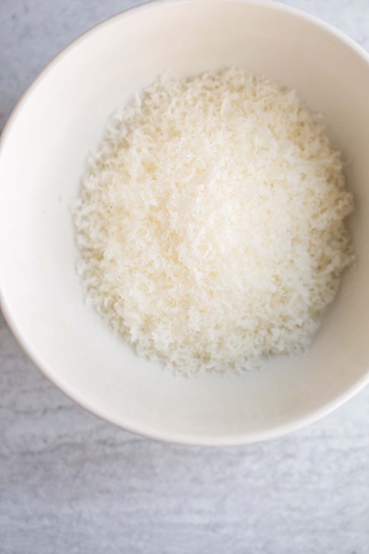 Freshly grated parmesan cheese in a bowl.