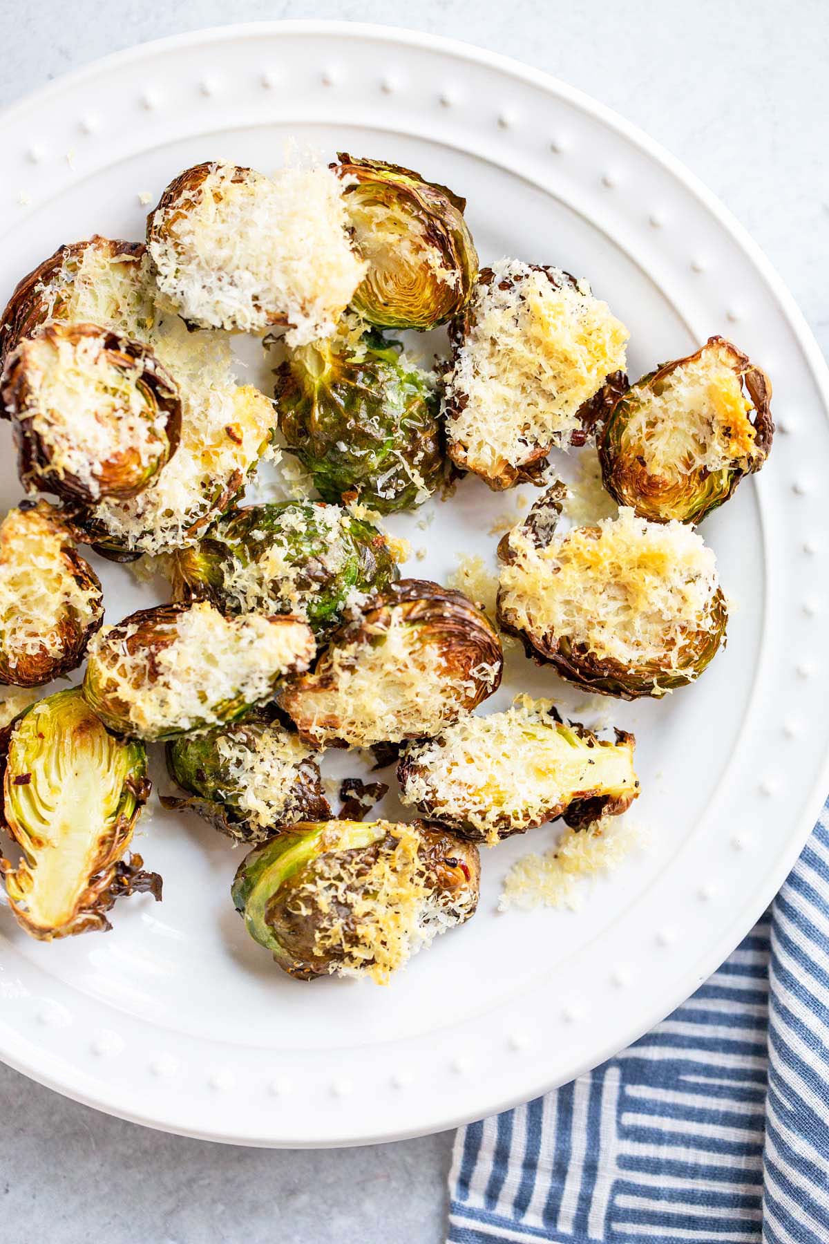 Air fried parmesan brussels sprouts on a white plate.