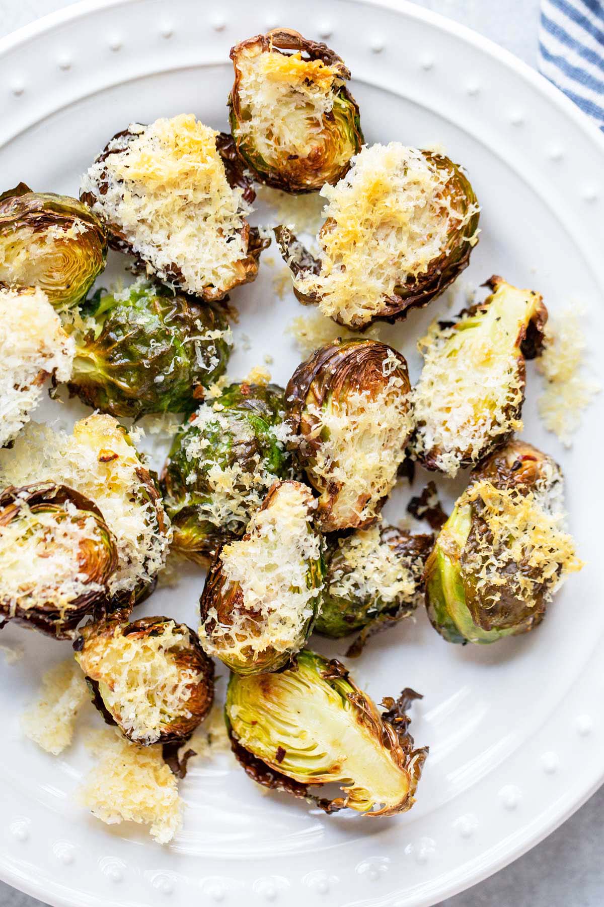 Air fried parmesan brussels sprouts on a white plate.