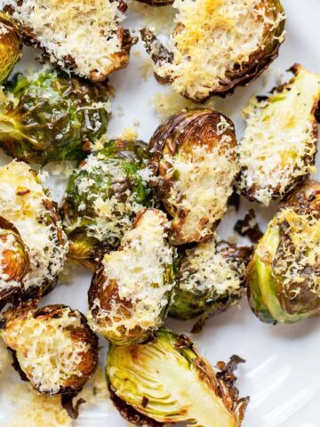 Air fried parmesan brussels sprouts on a white plate.
