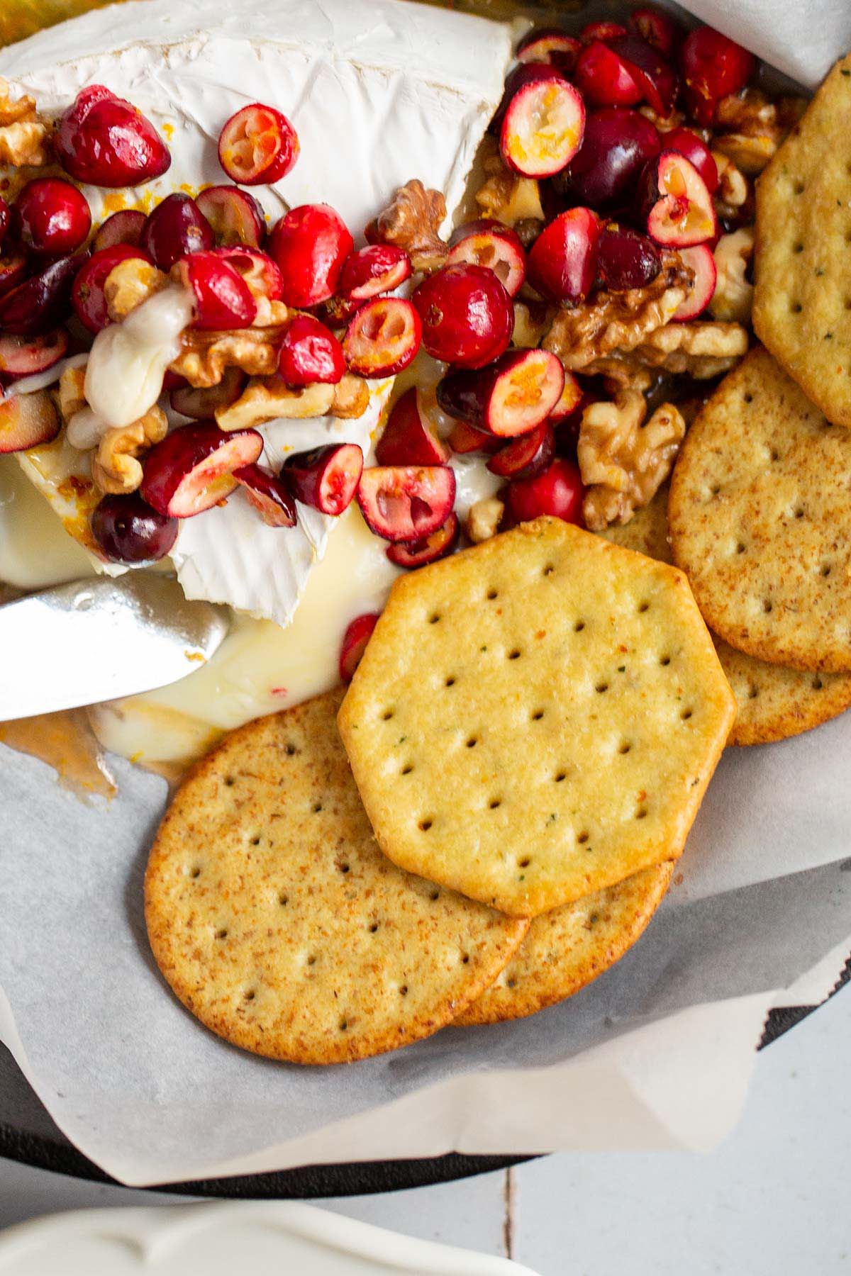 Baked brie with cranberries and walnuts with crackers on the side.