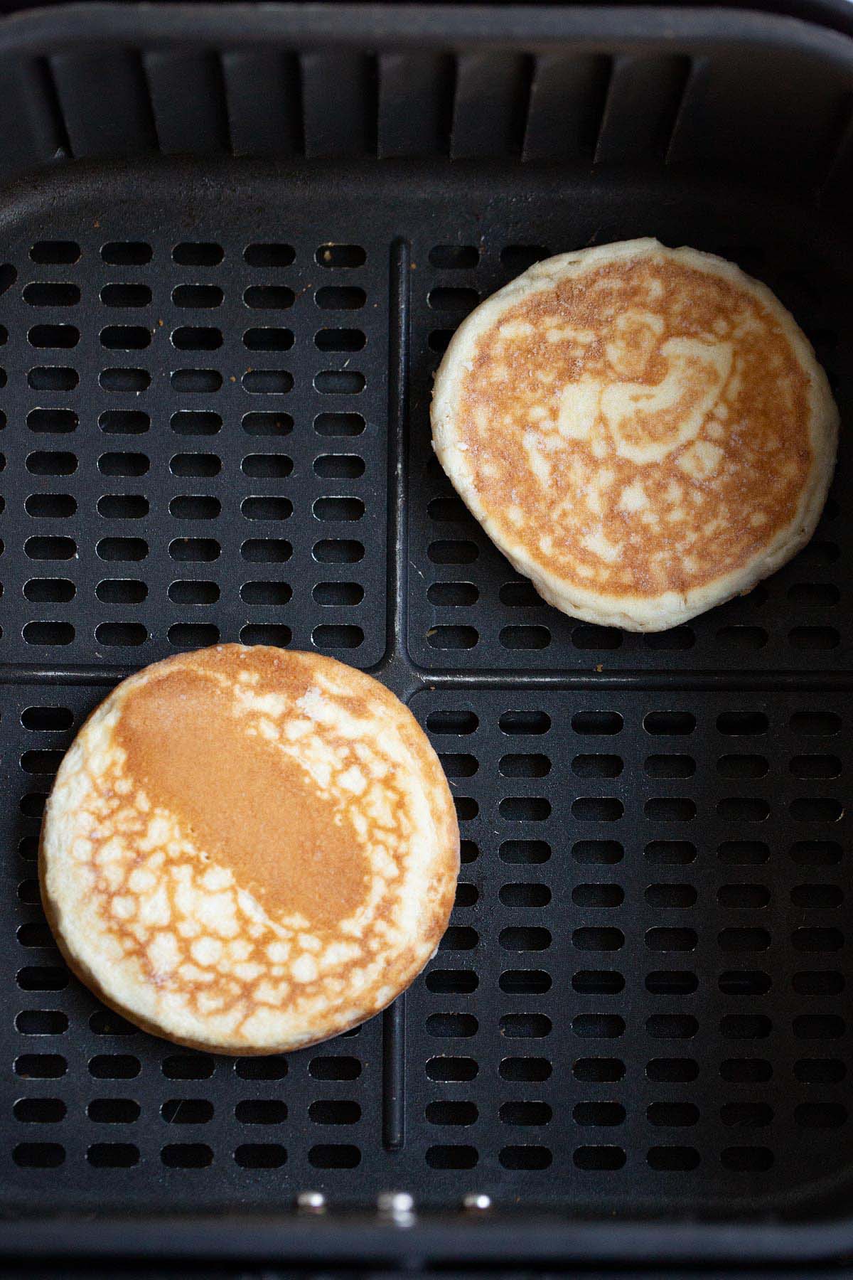 Uncooked griddle cakes in air fryer.