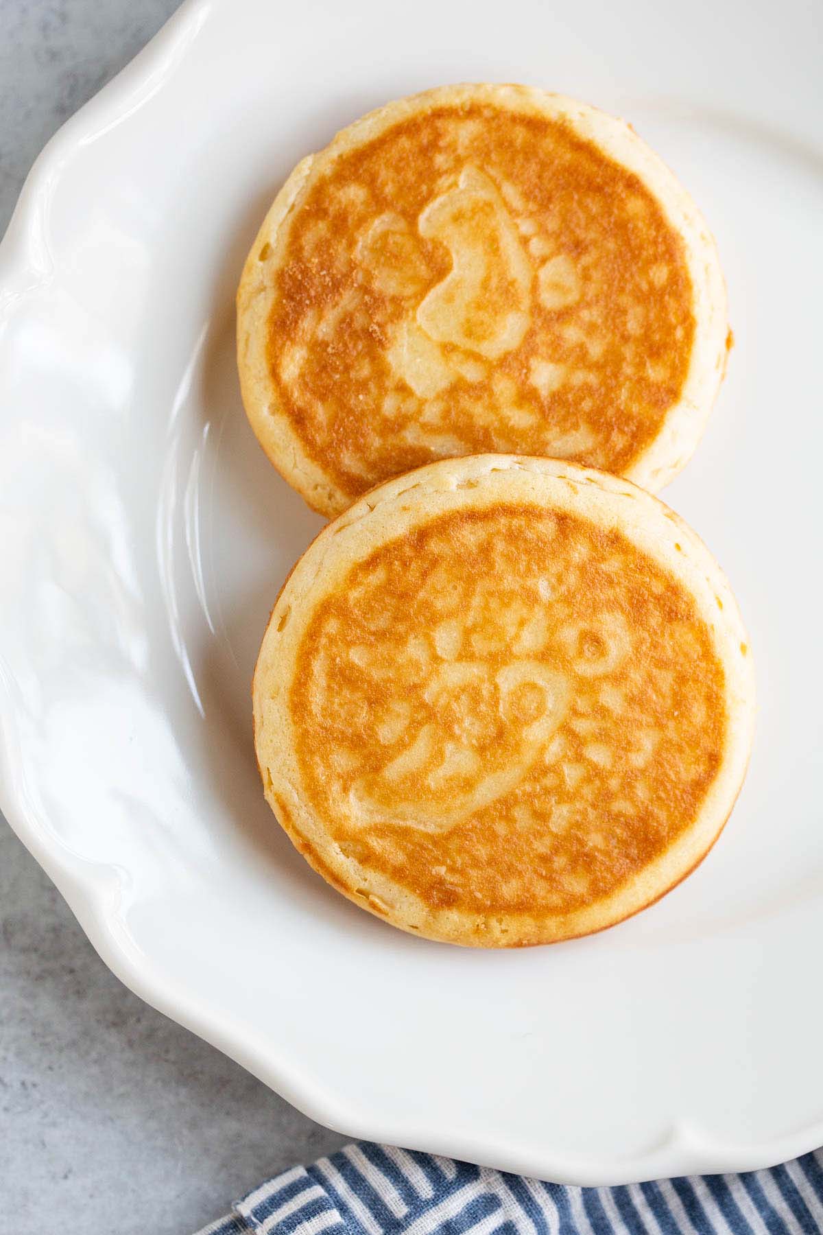 Cooked griddle cakes on a white plate.