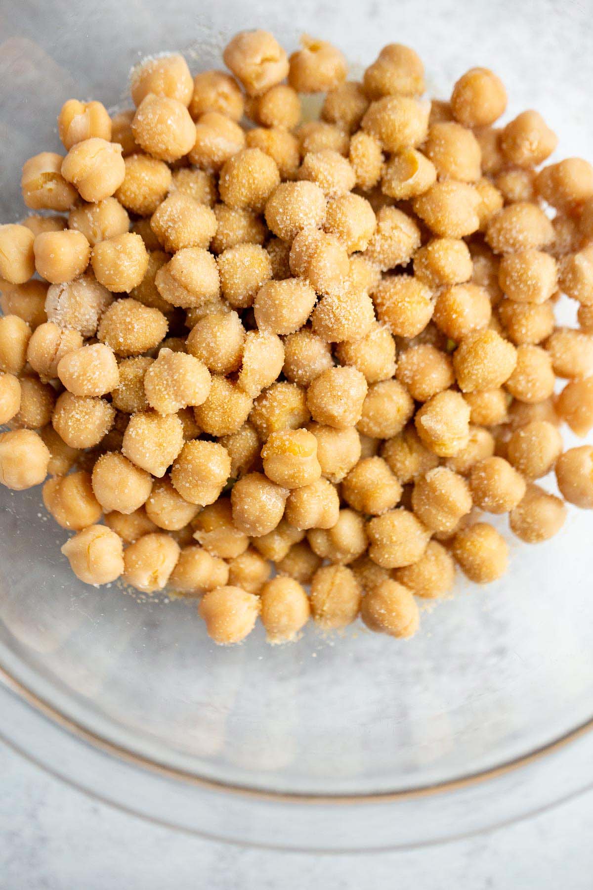 Chickpeas in a glass bowl with seasonings.