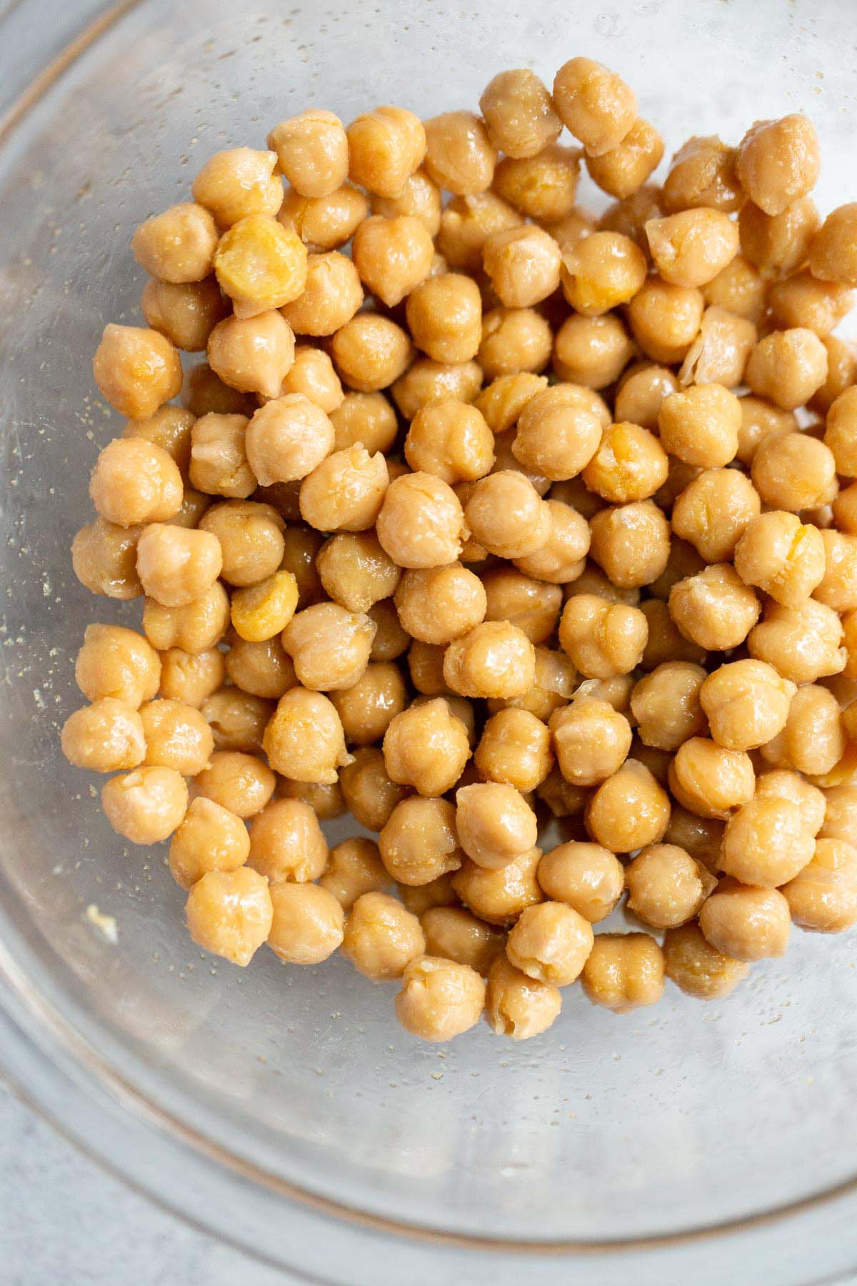 Chickpeas in a glass bowl with seasonings.