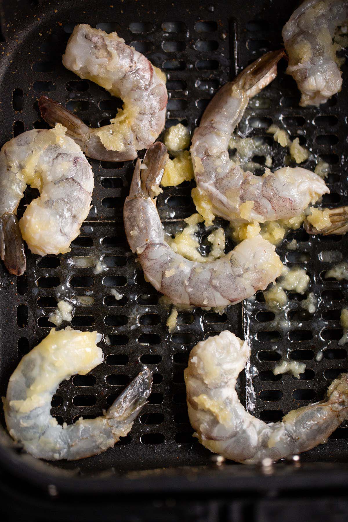 Uncooked garlic butter shrimp in air fryer.