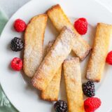 Air fried french toast sticks with berries and powdered sugar.