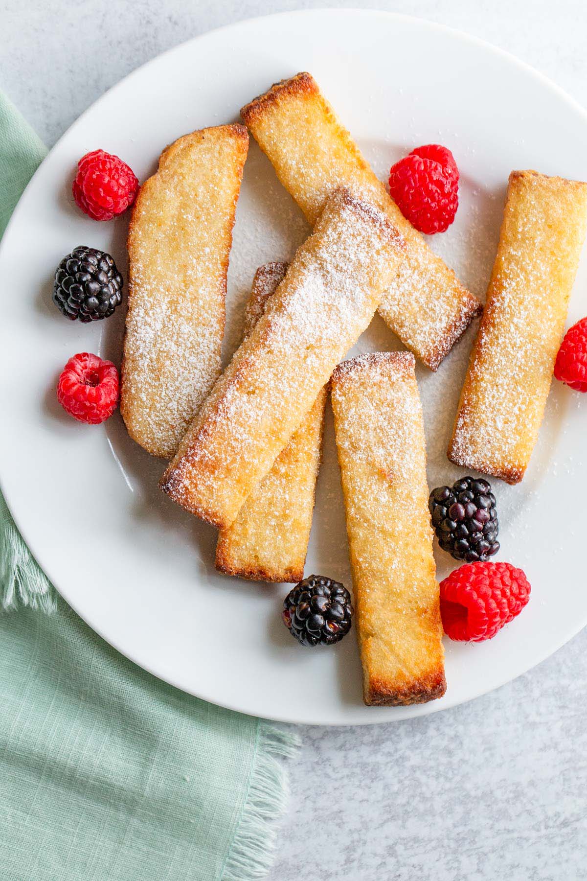 Air fried french toast sticks with berries and powdered sugar.