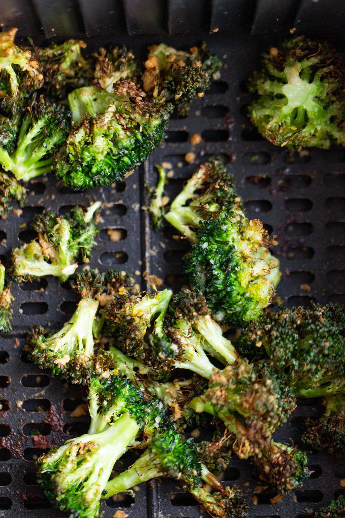 Air fried parmesan broccoli in air fryer basket.