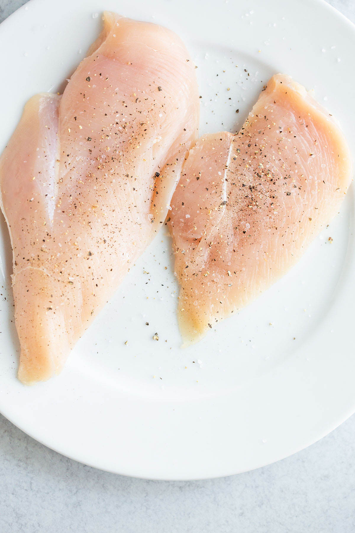 Chicken breast seasoned with salt and pepper.