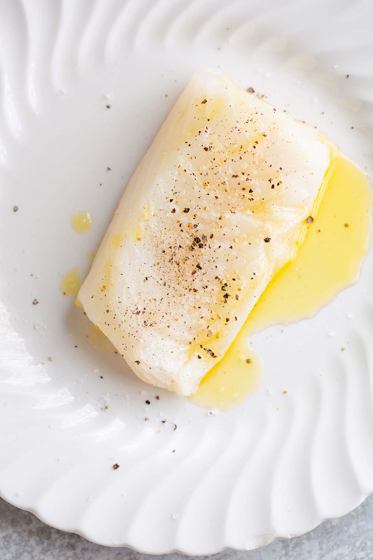 Cod drizzled with olive oil and seasoned with salt and pepper.