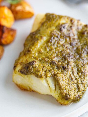 Air fried pesto cod on a plate.