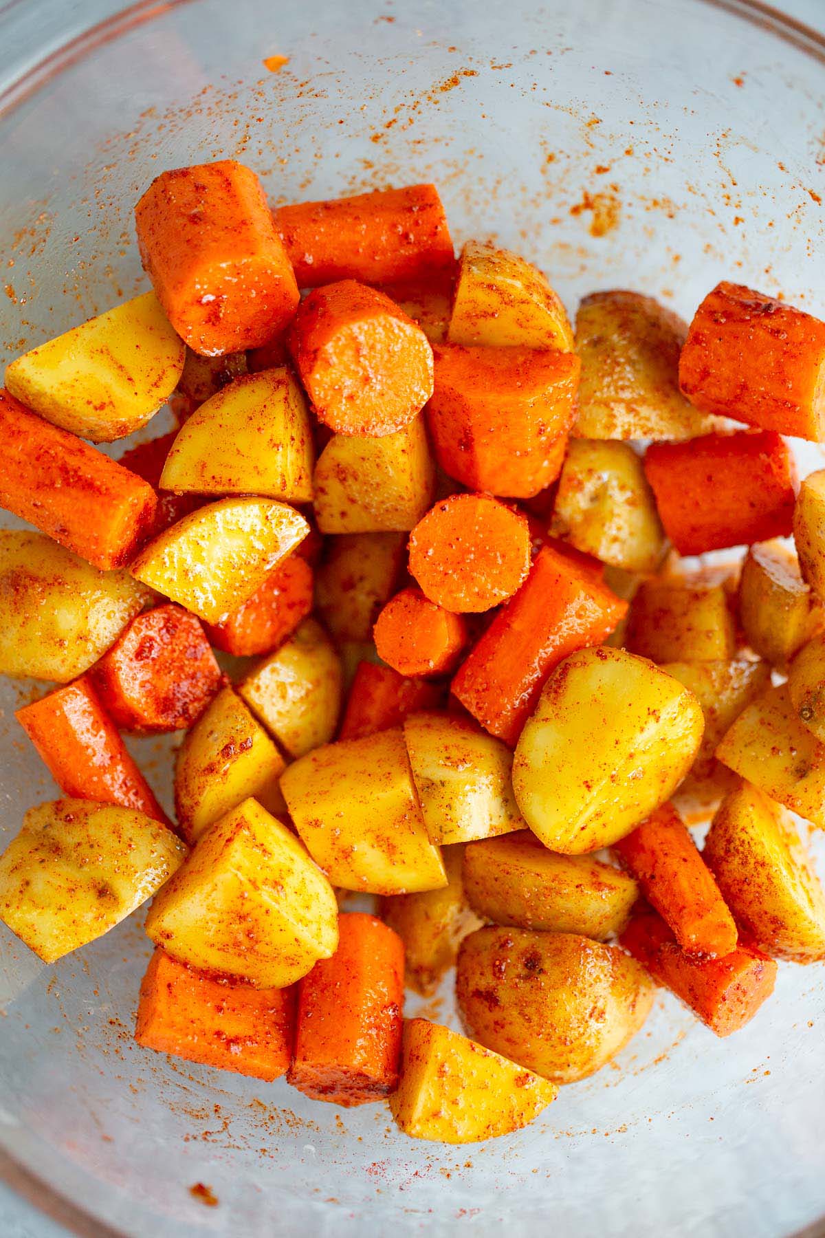 Seasoned potatoes and carrots in a bowl.