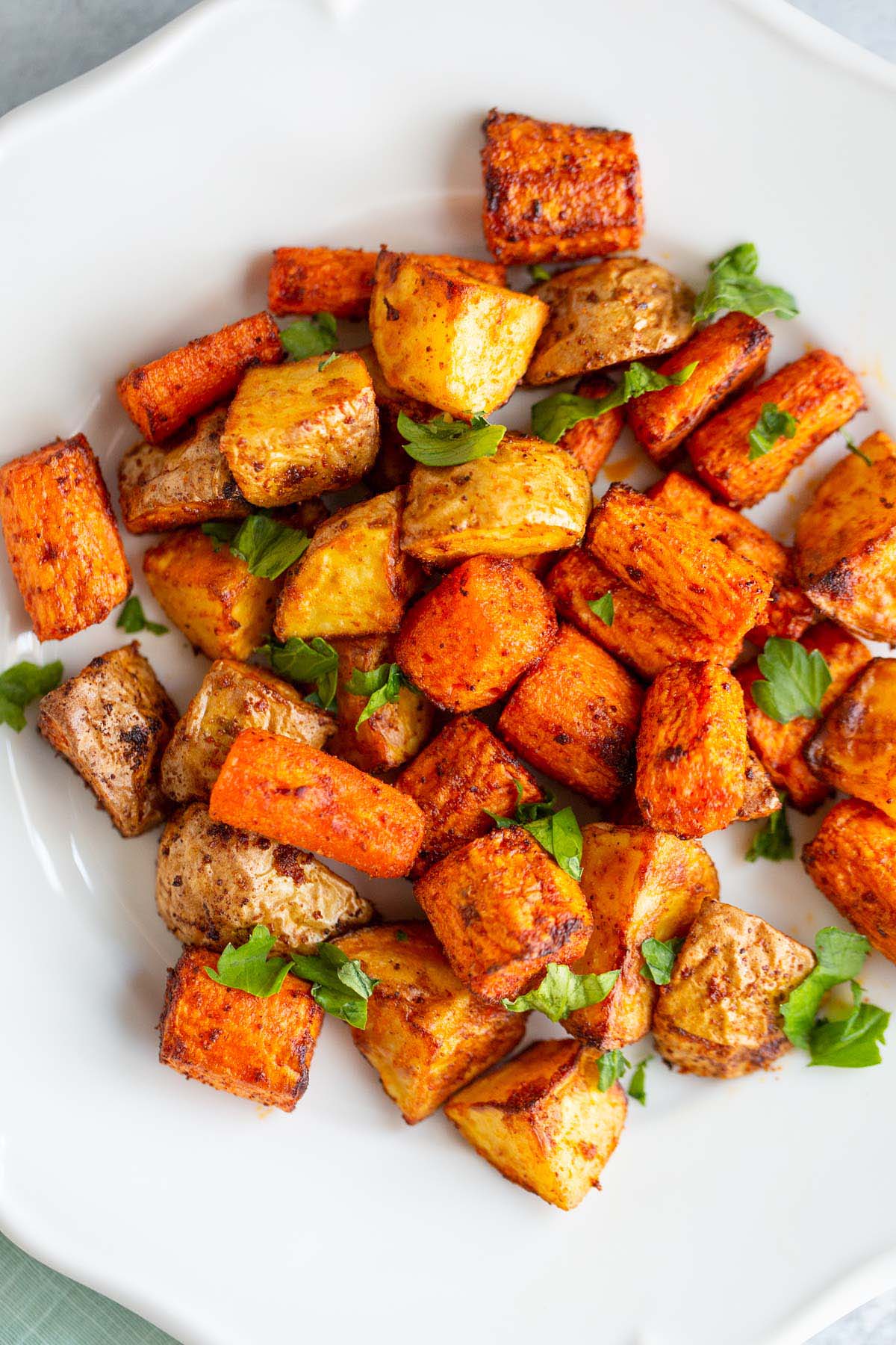 Potatoes and carrots on a white plate.