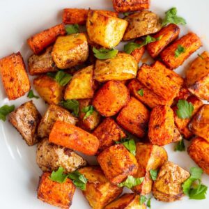 Potatoes and carrots on a white plate.