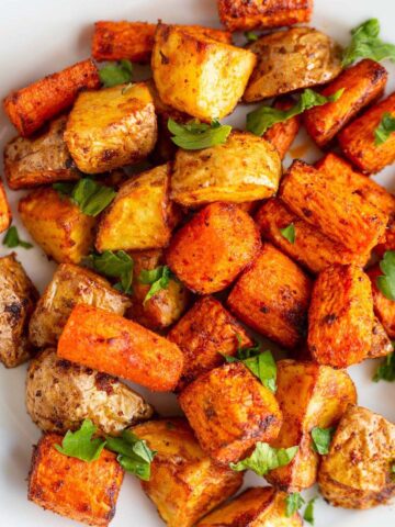 Potatoes and carrots on a white plate.