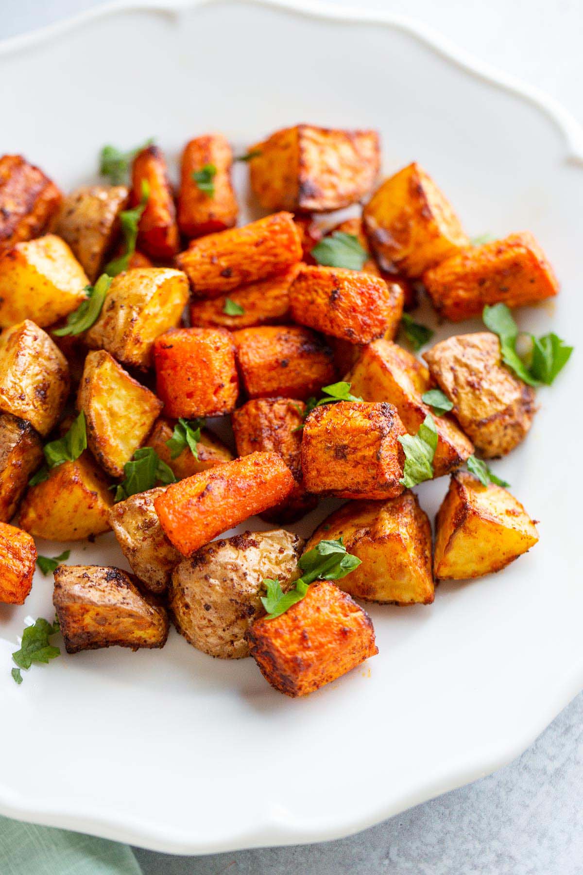 Potatoes and carrots on a white plate.